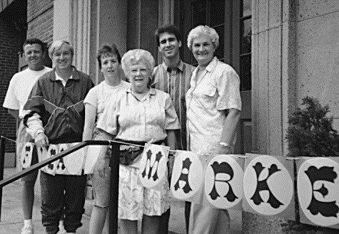 Black and white historical photo of Friends posing at a flea market fundraising event.