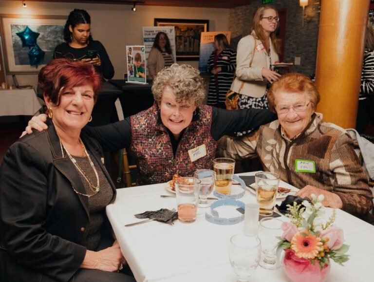 Three women smiling at the YMCA Celebration Dinner in 2025.